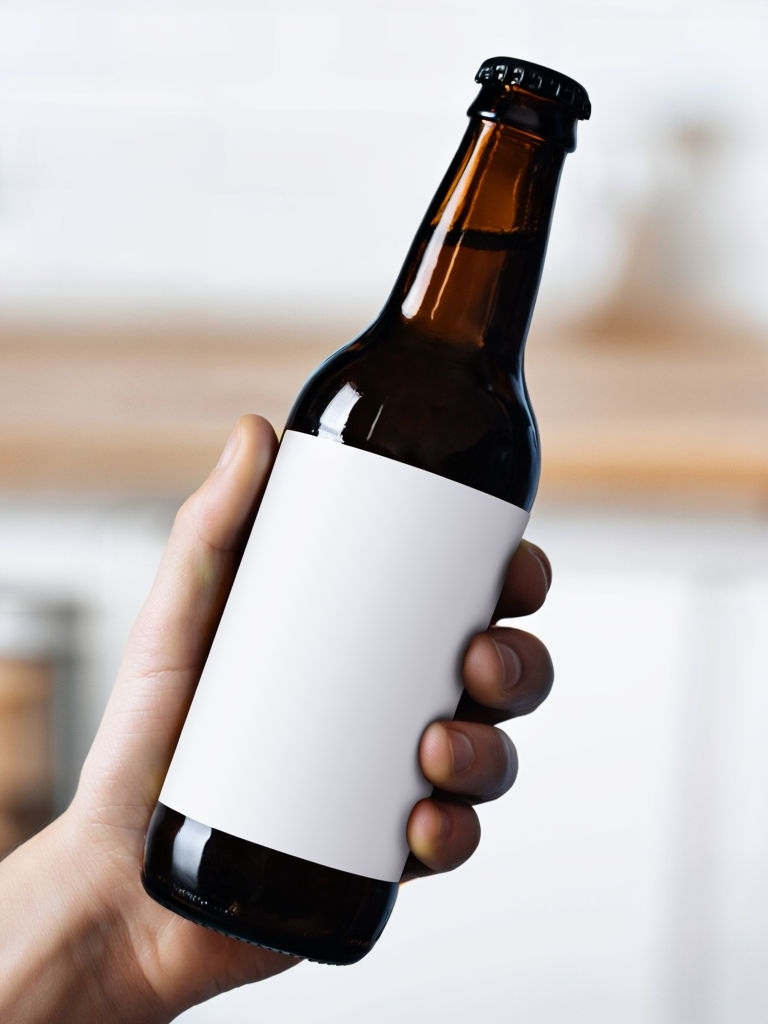 Close-Up of Hand Holding Dark Brown Beer Bottle Photograph Mockup