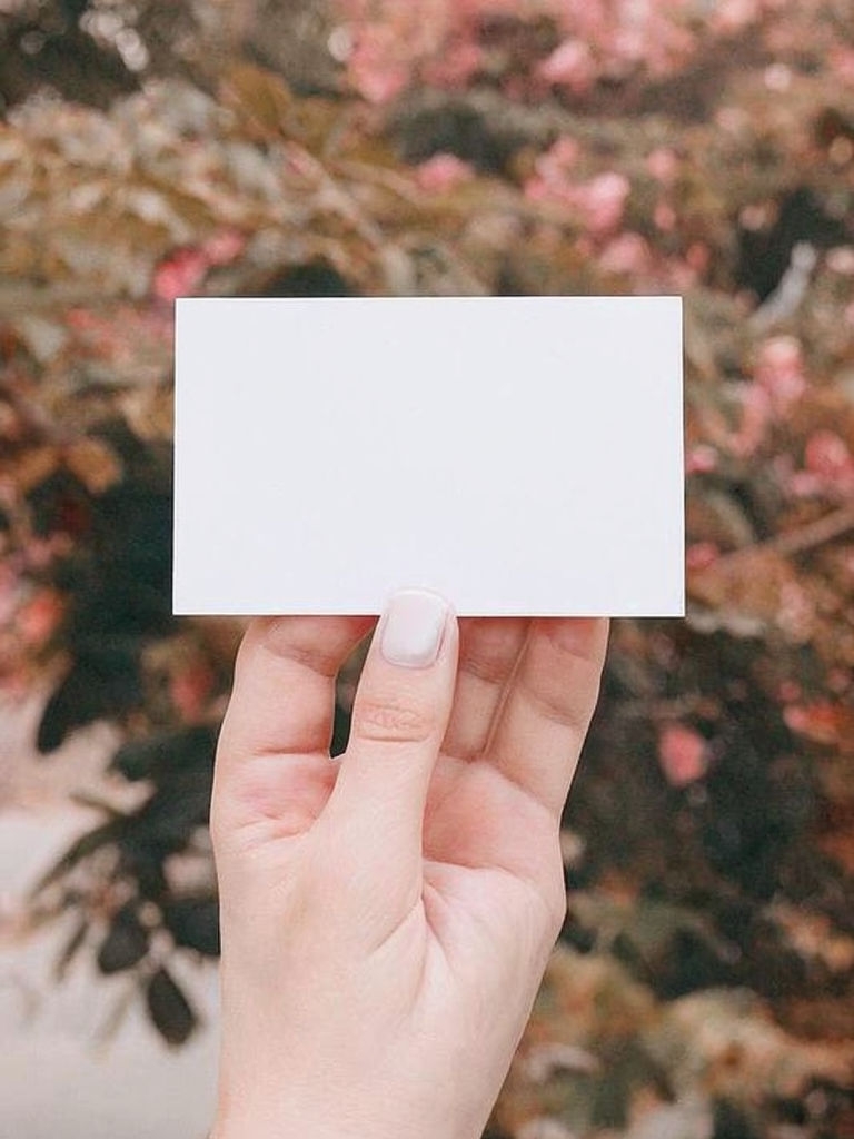 Elegant Hand Holding Plain White Card in Natural Setting Mockup