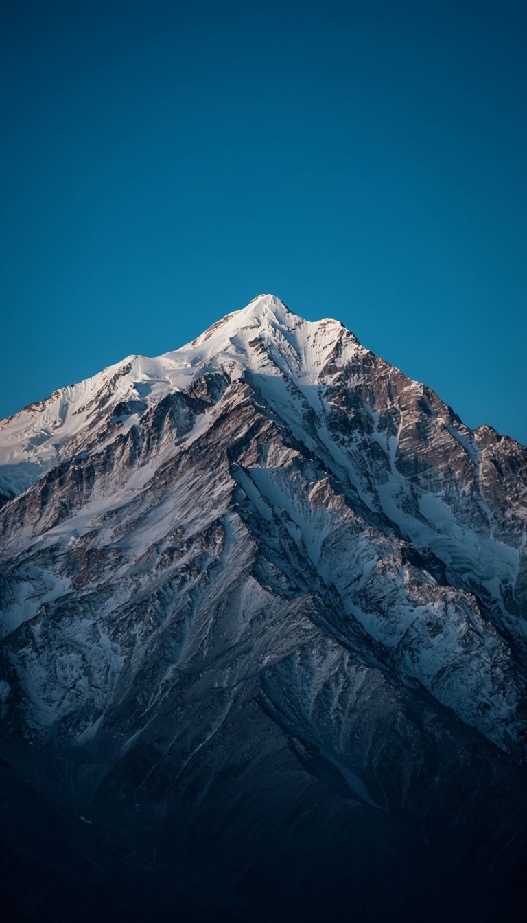 Majestic Snow-Capped Mountain Peak Under Clear Blue Sky Mobile Wallpaper